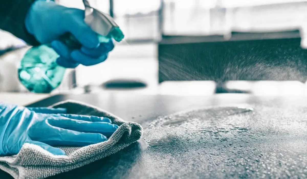 A cleaner wipes the surface with a microfiber cloth