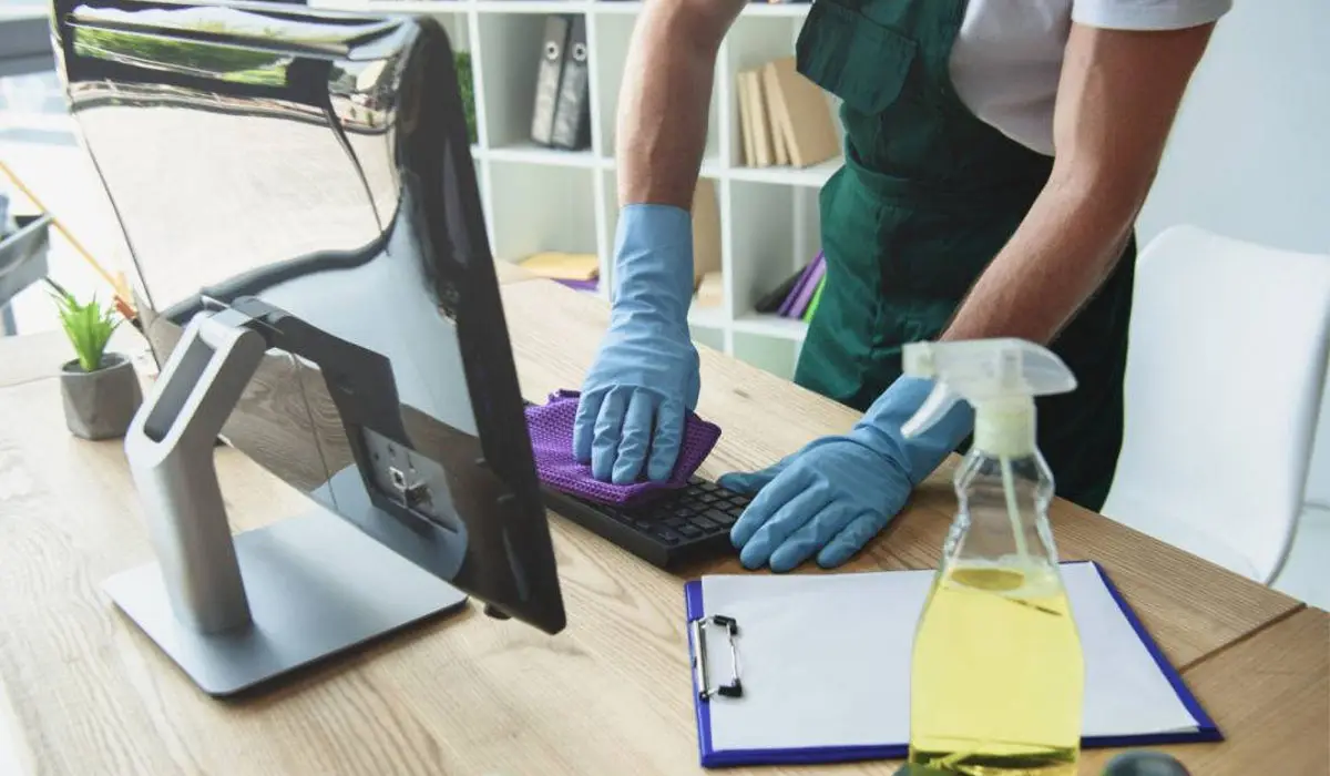 professional cleaner wiping the desktop keyboard