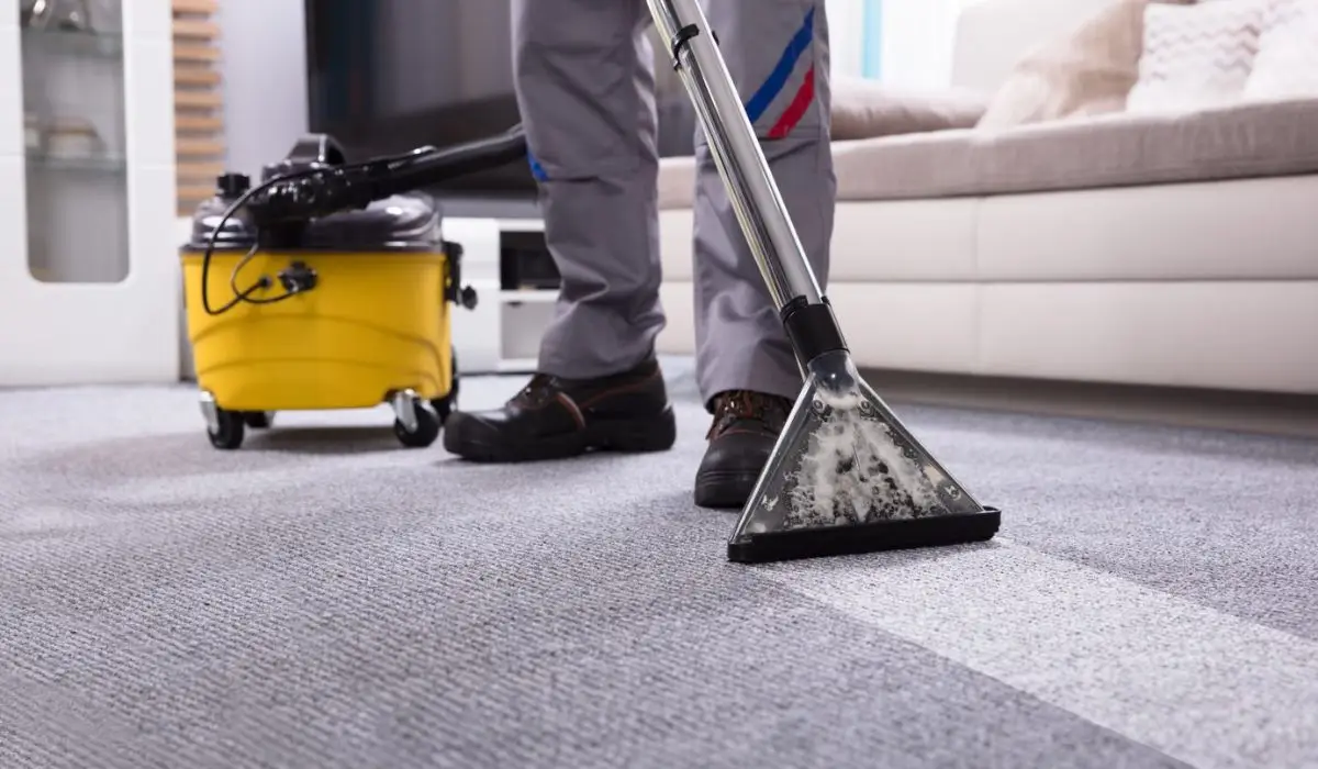 a man vacuuming the carpet